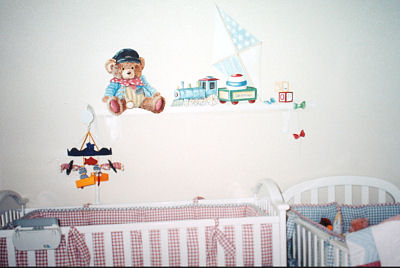 A teddy bear choo choo train theme nursery wall mural painted and designed <br>by Lisa Desantis-Kirchmer of Art of Walls Inc. in a baby boy nursery room with red and white and blue and white gingham baby crib bedding sets.