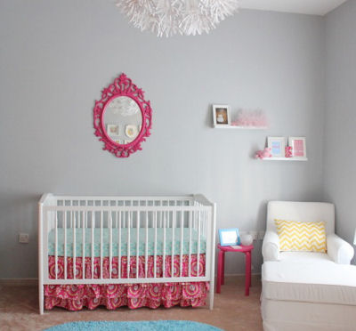 Pops of bright fuchsia pink in this baby girl's nursery are the perfect complement for the soft, grey nursery wall paint color.