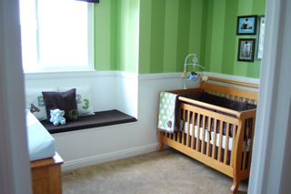 The window in the baby's nursery with decorative ABC accent pillows and chocolate brown cushion
