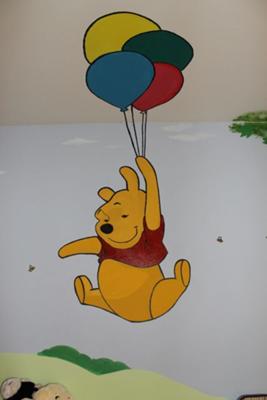 A closeup view of Pooh Bear taking a balloon ride 