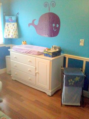 Purple whale nursery wall decal over the baby's changing table dresser combo. Ocean Wonders Diaper Stacker, Sea Babies Hamper