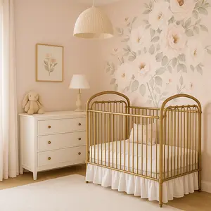 Baby girl nursery with blush pink walls, floral peony flowered wallpaper and burnished gold crib
