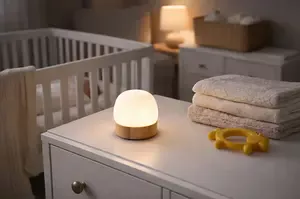 Soft nursery night light glowing beside a crib for calm overnight feeding and diaper changes