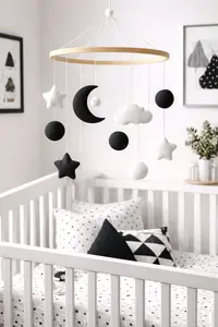 DIY black and white crib mobile made with simple high contrast felt moon, stars, and circle shapes for a high contrast baby nursery