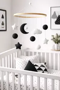 DIY black and white crib mobile made with simple high contrast felt moon, stars, and circle shapes for a high contrast baby nursery