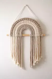 Boho macrame wall hanging pattern in soft neutral tones styled in a warm nursery