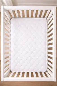 Crib mattress inside a standard crib showing the space around the mattress edges