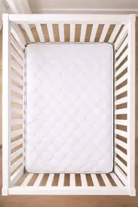 Crib mattress inside a standard crib showing the space around the mattress edges