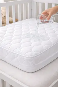 Waterproof crib mattress protector fitted securely on a standard crib mattress