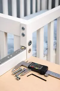 Baby crib corner with crib screws and hardware secured correctly during assembly