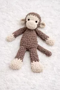 Soft crochet monkey lovey pattern made with plush yarn and floppy limbs for baby security comfort
