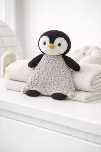 Crochet penguin lovey pattern with visible stitches and compact snuggler body with loop corners
