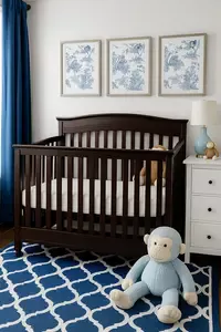 Delta brand baby crib in an elegant blue and white monkey themed nursery for a baby boy with framed monkey prints and plush toys