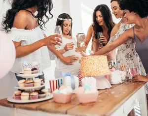 Women laughing while playing funny baby shower games at a baby shower