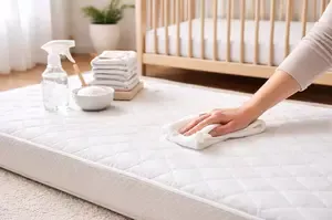 Cleaning a crib mattress with gentle supplies in a bright nursery
