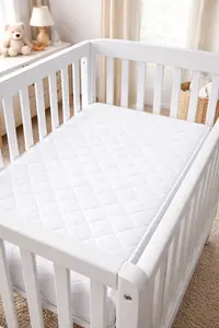 Firm mini crib mattress properly fitted inside a compact mini crib