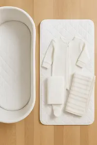 Simple newborn sleep essentials including a bassinet, swaddle, and fitted sheet