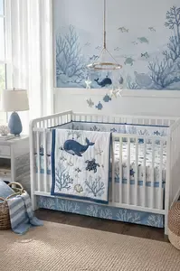 Ocean themed nursery with sea life crib bedding and soft blue coastal decor