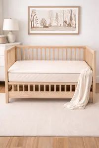 organic crib mattress fitted tightly inside a modern crib with clean nursery layout