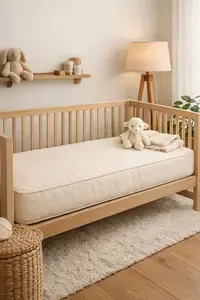Organic crib mattress with natural cotton cover inside a neutral baby nursery