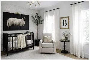 Black and white baby nursery with classic crib, patterned textiles, and soft gold accents