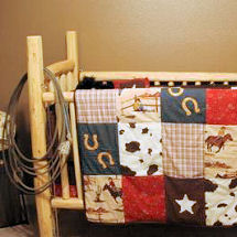 Old country wester baby boy cowboy nursery theme with rustic patchwork baby bedding and a homemade log crib