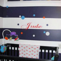 Red baby name decal letters on black and white painted horizontal stripes in a Beatles theme baby nursery