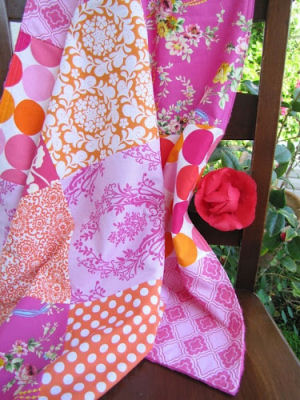 Minky Patchwork baby quilt featuring various shades of pink lavender and orange in floral and polka dots fabric