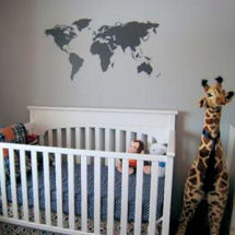 Gray and white neutral baby boy or girl modern giraffe nursery theme with world map wall decal and giant stuffed toy giraffe