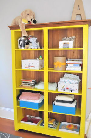 Bright yellow bookshelf painted with Confident Yellow Sherwin Williams paint