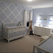 Baby blue green and white boy nursery with painted lattice pattern on an accent wall