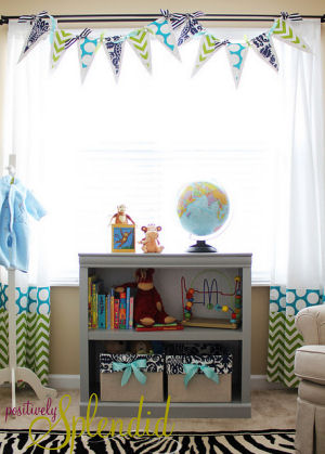 Homemade pennant banner made with custom fabrics for a baby's nursery window treatment.