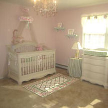 Pink and white princess nursery decorated with a crib crown and elegant crystal chandelier