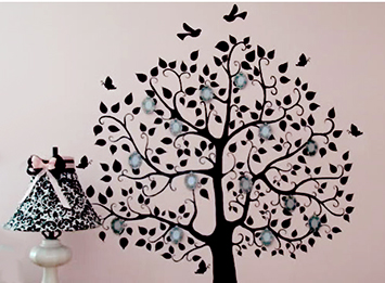 Hand painted family tree nursery wall art on a pink painted wall in a baby girl's room.