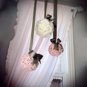 Pink silk rose balls hung by a chocolate brown satin ribbon