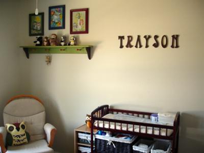 The nursery's wall shelf and framed  owl themed artwork that I painted and my baby boy's name spelled in letters. 