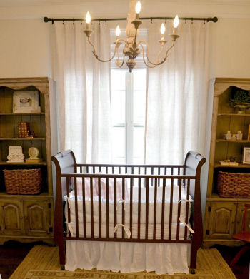 Vintage baby girl nursery decorated in pink and neutral colors with a sleigh crib and classic white crib bedding set