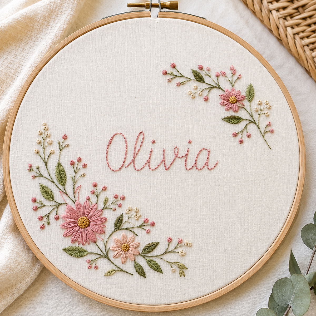 Finished baby name hand embroidery pattern with Olivia stitched in the center and delicate floral sprays around the name