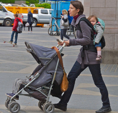 mom in central park with baby stroller and baby backpack