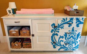 White dresser with a baby blue stenciled design painted using a large pattern