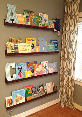 Floating shelves in a baby nursery take the place of a free standing bookshelf