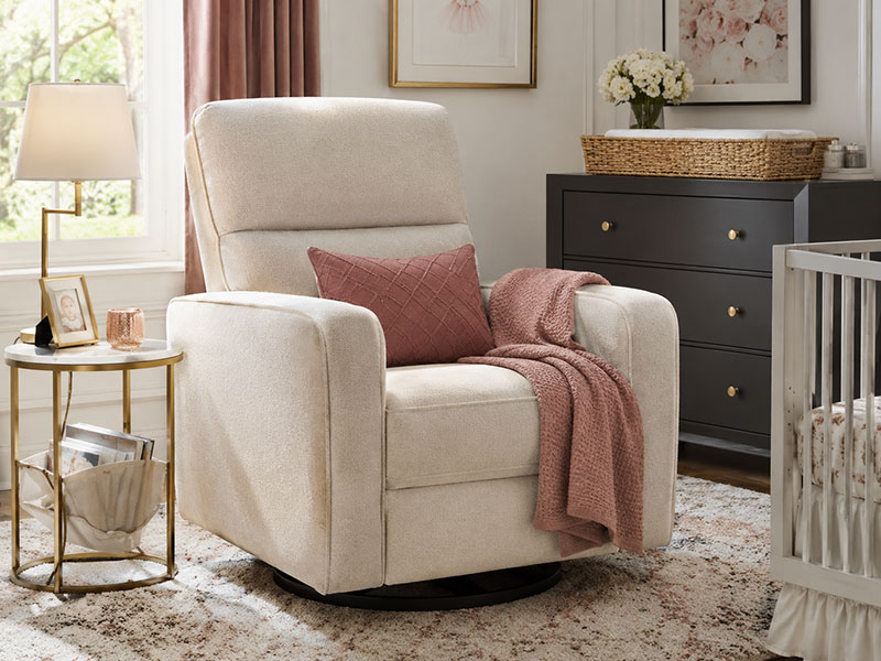 Breastfeeding nursery glider with supportive armrests in a modern nursery corner