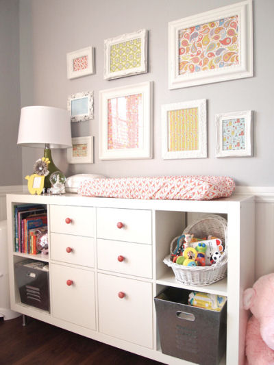 baby girl neutral gray nursery wall with wall arrangement of colorful framed fabric
