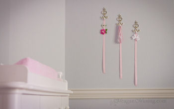 Shabby chic ivory hooks used to display baby girl hair bows on the nursery wall
