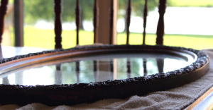 Oval shaped wood mirror frame in antique gold