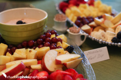 Fruit and chocolate dip complement the savory treats on the baby shower snack menu