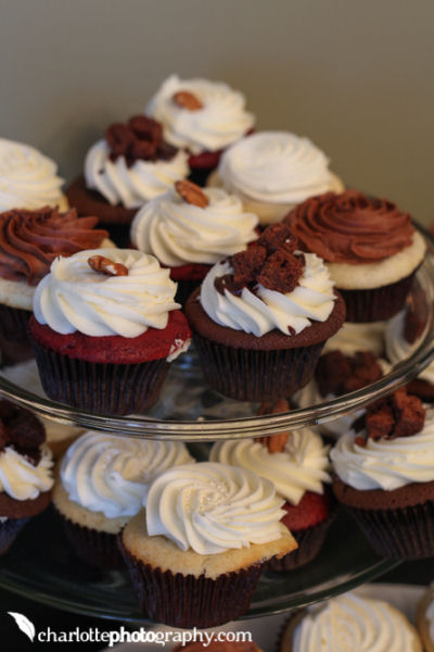 Vanilla and chocolate baby shower cupcakes with swirled buttercream icing topped with a pecan half arranged on a tower