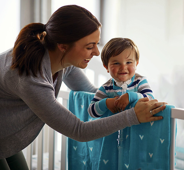 Sturdy baby crib mattress with baby standing up in crib.