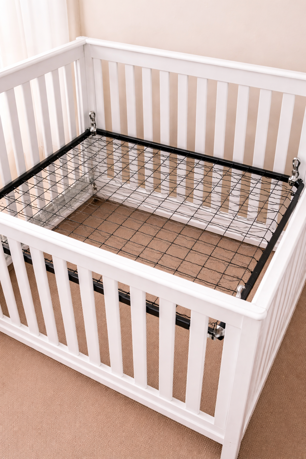 Metal crib mattress support frame with spring and hanging brackets installed inside a baby crib