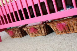 Baby crib painted hot pink using spray paint in a baby girl pink and green nursery room